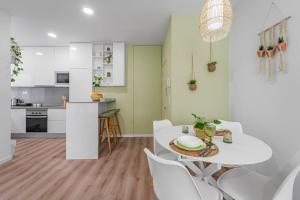 a kitchen and dining room with a white table and chairs at Green Living-Funchal in Funchal