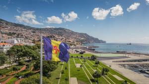 a flag in a park next to a body of water at Green Living-Funchal in Funchal