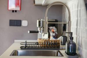 a kitchen sink with a bottle of soap and a faucet at Fajã Lodges - Studio Ash in São Vicente