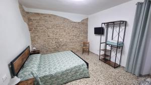 a bedroom with a bed and a brick wall at La Paulotta in Paroldo
