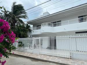 una cerca blanca frente a una casa blanca en CASA VERANO, en San Andrés