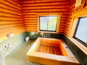 a bathroom with a tub in a wooden house at wood house in Hita
