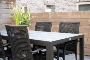 a table with wicker chairs and a table with flowers at Vakantiewoning Huis 8 in Tongeren