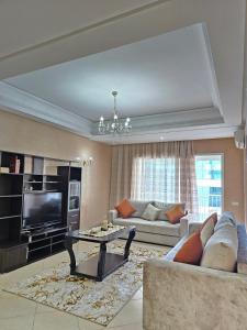 a living room with a couch and a tv at City Center Apartment in Tangier
