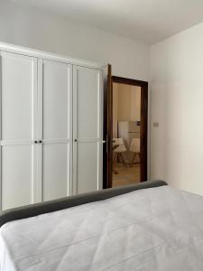 una camera da letto con un letto e uno specchio di Fronte Mare Apartment Private Beach & Free Park a Lido di Jesolo