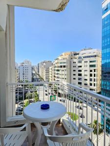 a table and chairs on a balcony with a view of a city at City Center Apartment in Tangier