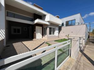 ein großes weißes Haus mit Balkon in der Unterkunft Casa de Alto Padrão Verdes Campos POA in Porto Alegre
