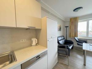 Una cocina con refrigerador y una mesa y sillas. en Tief 10 Wattwurm, en Wangerland