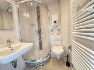 a bathroom with a shower and a sink and a toilet at Tief 10 Wattwurm in Wangerland +52 photos
