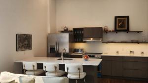 Una cocina con fregadero y una encimera con sillas. en Luxury, Convenience and Comfort Near Acadia!, en Ellsworth