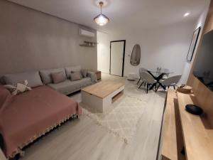 una sala de estar con un sofá y una mesa en Le luxe appartement, en El Haouach 2 fotos más
