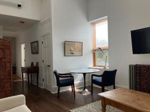 Una sala de estar con una mesa y sillas y un televisor. en Luxury, Convenience and Comfort Near Acadia!, en Ellsworth