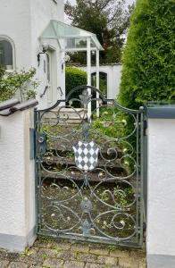a black gate with a checkered sign on it at Estelada Boarding Houses Oberhaching in Oberhaching