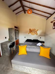 a bedroom with a bed with yellow pillows and a desk at Vila São Jorge in Barra Grande