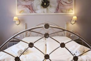 a bedroom with a metal bed with towels and a mirror at Antonio Old Town Residence in Prešov