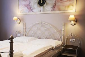 a bedroom with a white bed with a picture on the wall at Antonio Old Town Residence in Prešov