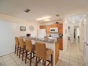a kitchen with a bar with chairs and a counter top at The Kingfish Cottage in South Padre Island