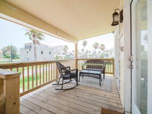 a porch with two chairs and a bench on it at The Kingfish Cottage in South Padre Island