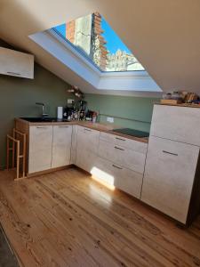 an attic kitchen with a skylight in the ceiling at Le nid de Raphaël rooftop in Le Puy en Velay