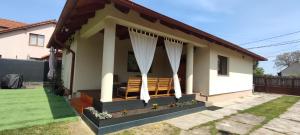 萨图马雷Silence Villa的庭院中带门廊和椅子的小房子