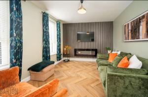 a living room with two couches and a tv at BridShu Den New build Townhouse in Larne