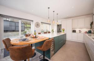 a kitchen with a table with chairs and a counter at BridShu Den New build Townhouse in Larne