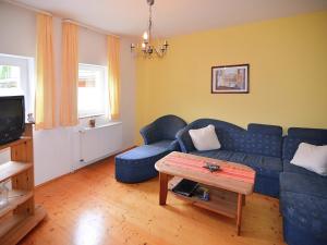 a living room with a blue couch and a table at Wohnung mit eigener Terrasse in Hüddingen in Bad Wildungen
