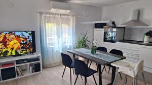 KomenPiramida Kras的带餐桌和电视的客厅