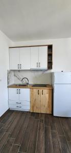 a kitchen with white cabinets and a sink at Summer Apartments in Shengjin in Shëngjin