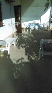 a group of white benches sitting next to a building at Peaceful House in Tribunj in Tribunj