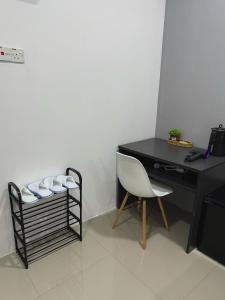 a black desk with a chair next to a table at Modern & Cozy Home Stay in Kampar