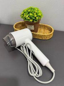 a blow dryer on a table next to a basket at Modern & Cozy Home Stay in Kampar