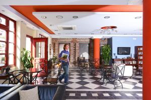 a woman standing in a room with a checkered floor at Sirena Residence & Spa in Marathokampos