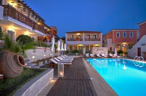 a villa with a swimming pool at night at Sirena Residence & Spa in Marathokampos