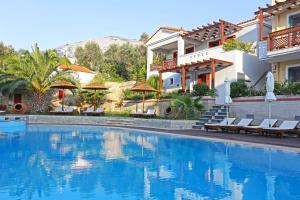 a swimming pool in front of a house at Sirena Residence & Spa in Marathokampos