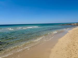 a sandy beach with the ocean in the background at La Casa verde in Galatone