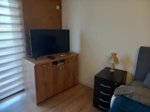 a living room with a flat screen tv on a wooden cabinet at Apartman Ika 4N in Kraljevo