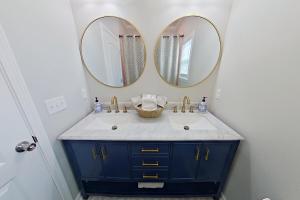 une salle de bain avec un lavabo et deux miroirs dans l'établissement Bella's Charming Cottage, à Thomasville 16 autres photos