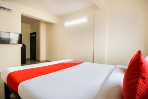 a bedroom with a white bed with red pillows at Hotel O Galaxy Near INOX in Yeraoda +29 photos