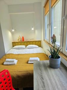 a bedroom with a large bed and a red chair at Lovely Sparkly Apartment in Krakow