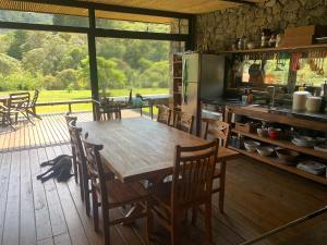 eine Küche mit einem Holztisch und einigen Stühlen in der Unterkunft Fazenda Caminho do Ouro in São José do Barreiro