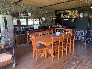eine Küche mit einem Holztisch und Stühlen in der Unterkunft Fazenda Caminho do Ouro in São José do Barreiro + 42 Fotos
