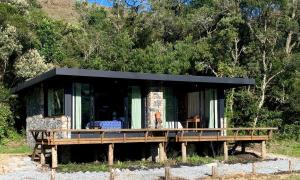 ein Haus mit einer großen Terrasse im Wald in der Unterkunft Fazenda Caminho do Ouro in São José do Barreiro