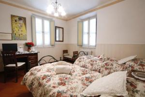 sypialnia z 2 łóżkami, biurkiem i oknami w obiekcie Bed&Breakfast 1912 w mieście Fermo
