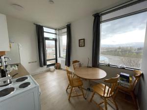 a kitchen and dining room with a table and a window at Dalía in Búðardalur
