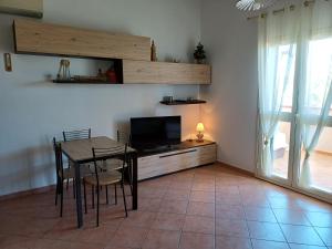 a dining room with a table and a television at Domo Susy in Orosei