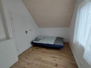 a bedroom with a bed in the corner of a room at Cozy House Trzęsacz in Trzęsacz