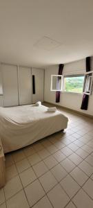 a bedroom with a bed and a large window at La maison des vendangeurs in Vergisson