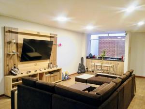 a living room with a couch and a flat screen tv at Restobar & Hotel Campestre Aisha in Cocachacra