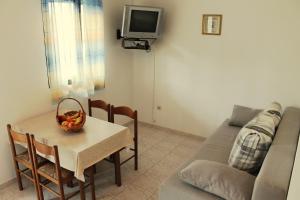 una sala de estar con una mesa y un sofá en Apartments Lancek, en Ivan Dolac
